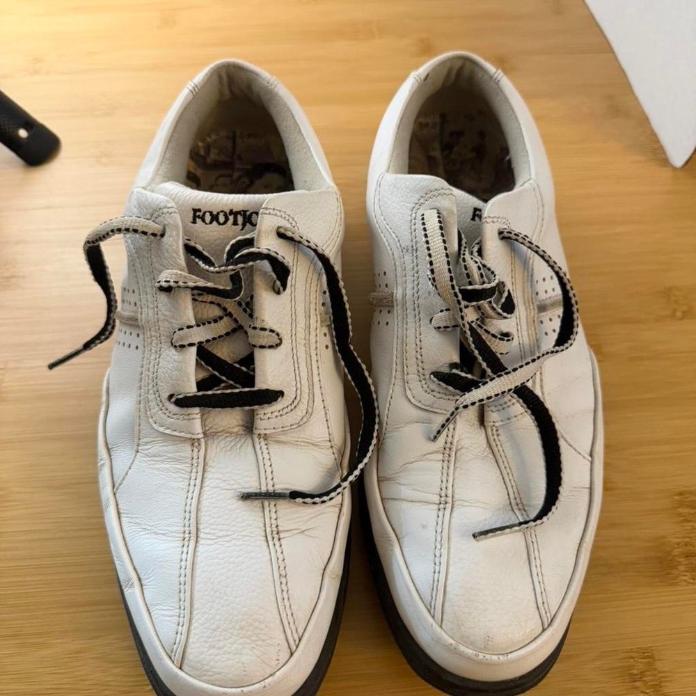 White leather FootJoy golf shoes with black stitching